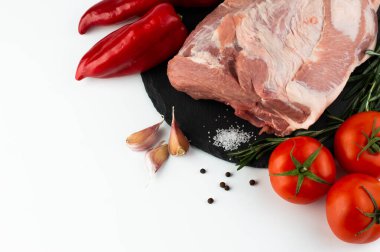 Beyaz bir tabakta, domates, biber, sarımsak, biberiye ve baharatlı domuz eti. Metin yazmak için boşluk içeren kartpostal.