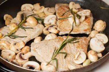 Domuz pirzolası tavada kızartılır. Mantarlı ve biberiyeli..