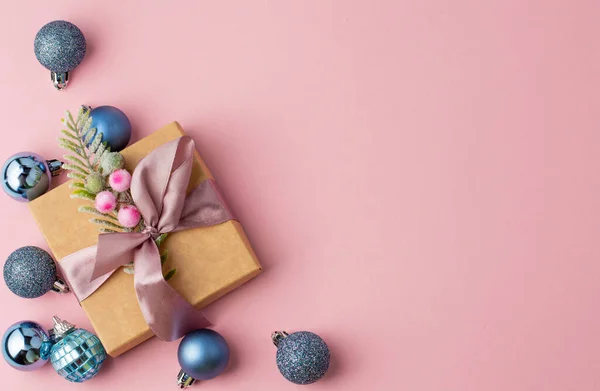 蓝色的圣诞装饰品和精美的盒子躺在粉色的背景上 上面有一个写文字的地方 圣诞贺卡 — 图库照片