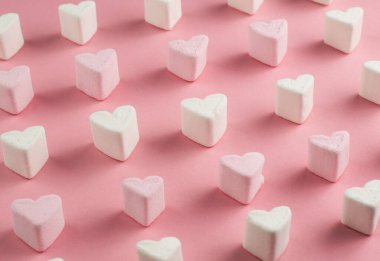 Kalpler beyaz ve pembe marşmelovlar pembe arka planda sıralanır. Romantik baba..