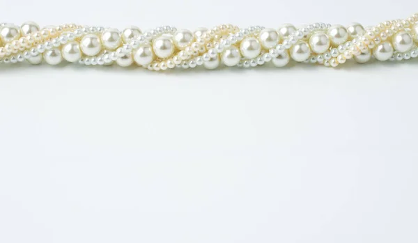 一条由不同尺寸的珠子做成的项链 白色背景上有白色的米色 上面有书写文字的地方 从上方看 — 图库照片