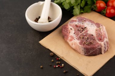 Karanlık bir masada, bir parça domuz eti, baharatlar, otlar, domatesler, yer baharatlı bir havan topu..