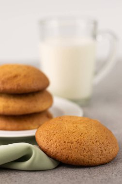 Ön planda, bulanık bir kurabiye resmi ve arka planda bir fincan süt. Ev yapımı yemek..