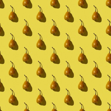 Sarı arka plandaki armutların kusursuz deseni. Sert ışıklandırmalı fotoğraf.