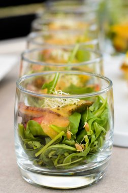 Roka salatası, filizlenmiş tahıllar, sebzeler, bardakta servis edilen yemekler..