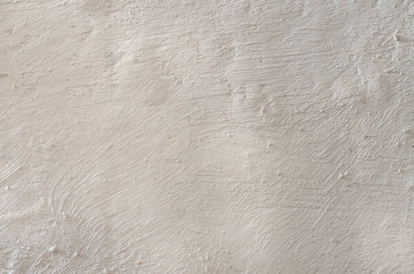 Rough, textured plaster on the wall. Light uneven background.Whitewashed wall.