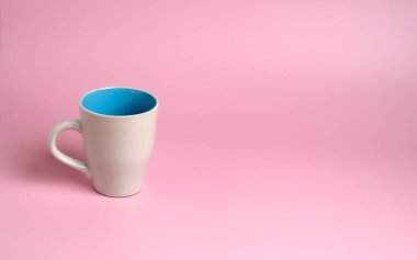 Pembe arka planda mavi ve saplı beyaz bir fincanın ayrıntıları