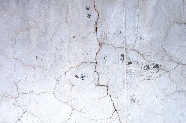 Beyaz bir duvarın ayrıntıları zaman geçtikçe çatlamış ve bozulmuştur.