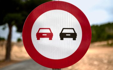 Mavi gökyüzü ve arka planda ağaçlar olan trafik işaretini geçemeyeceğinin ayrıntıları
