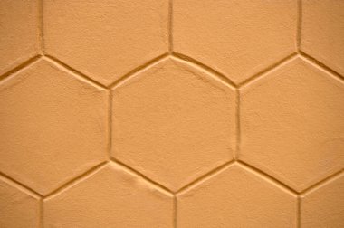 Üzerinde altıgen geometrik şekiller işlenmiş sarı bir duvarın ayrıntıları