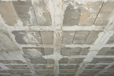 İnşaat halindeki bir binanın gri beton tavanının ayrıntıları.