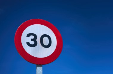 Mavi bir gökyüzü üzerinde saatte 30 kmh hız sınırı trafik işaretinin ayrıntıları