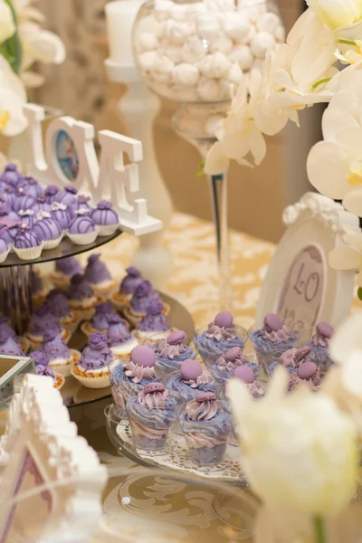 Конфеты шведский стол с широким разнообразием конфет, с белыми и фиолетовыми цветами — стоковое фото