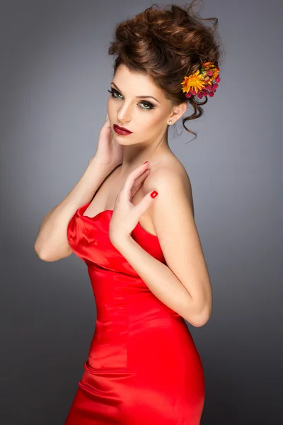 Fashion shot of a gorgeous young woman in elegant red dress. — Stock Photo, Image