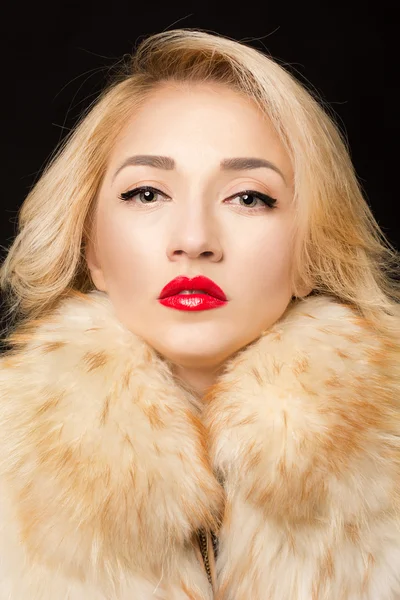 Portrait of a beatyful blond woman in fur clothes. Red lip stik — Stock Photo, Image