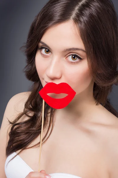 Beauty happy girl with Valentine lips. Smiling surprised model girl takes lips shaped red. — Stock Photo, Image