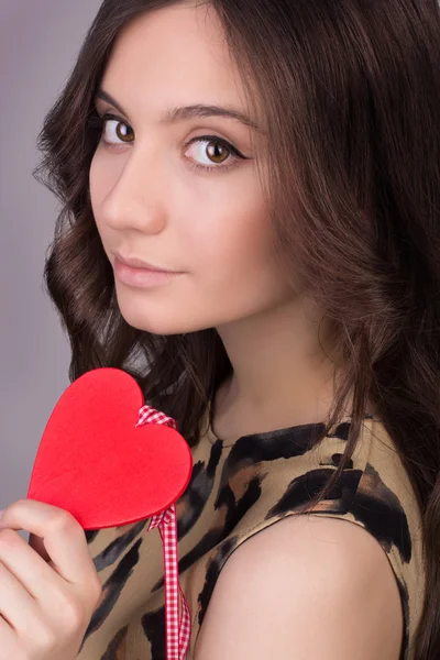 Love and valentines day woman holding heart smiling cute and adorable. Valentine's Day. Portrait of Beautiful gorgeous smiling woman with glamour bright makeup and red heart in hand — Stock Photo, Image