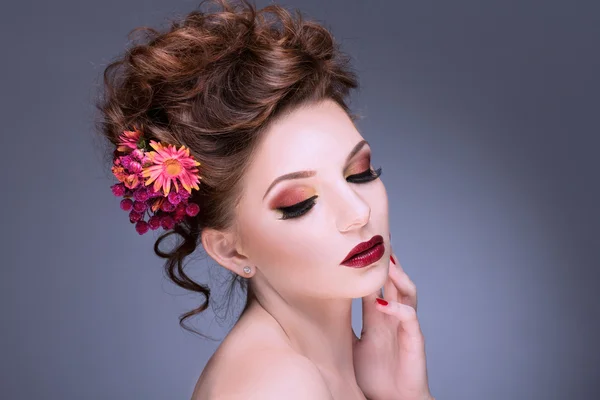 Moda Belleza Modelo Chica con Flores Pelo. Novia. Perfecto maquillaje creativo y estilo de pelo. Peinado. Ramo de flor hermosa — Foto de Stock