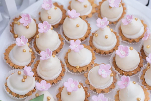 Bandeja con deliciosos pasteles. Elegante mesa dulce con pasteles grandes y pequeños, cupcakes, pasteles en la cena o fiesta del evento. La torta estalló. Bandeja con deliciosos pasteles — Foto de Stock