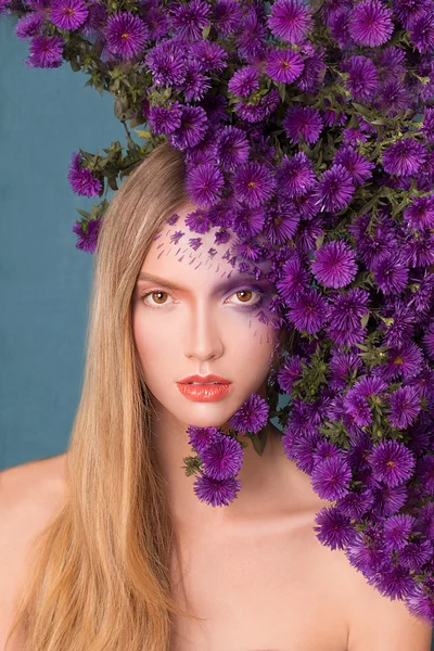 Modemodel mit großer Frisur und Blumen im Gesicht. — Stockfoto