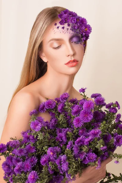 Modelo de moda con peinado grande y flores en la cara . — Foto de Stock