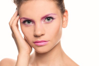 Beautiful Woman Touching her Face. Creativ pink makeup. Perfect Fresh Skin. Beauty brunette Model. Youth and Skin Care Concept. Studio shot. Isolated on white background