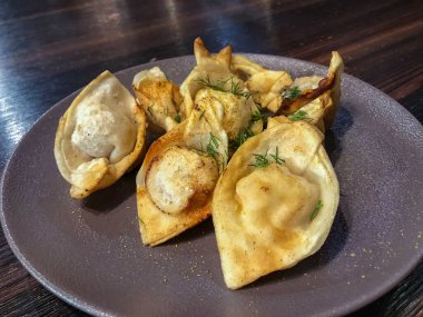 Et ile doldurulmuş kızarmış hamur tatlısı, doğranmış dereotu serpiştirilmiş.,..