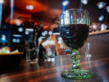 Bir bardak kırmızı şarap bir kafeye yakın, seçici odaklı, bulanık arkaplan..