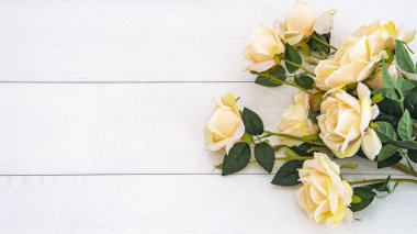 Ahşap beyaz arka planda şenlikli renkli güller, kopyalama alanı. Tebrik kartı doğum günü, sevgililer günü, düğün davetiyesi, hediye paketi, etiket, afiş modeli, tebrik kartı tasarım şablonu.