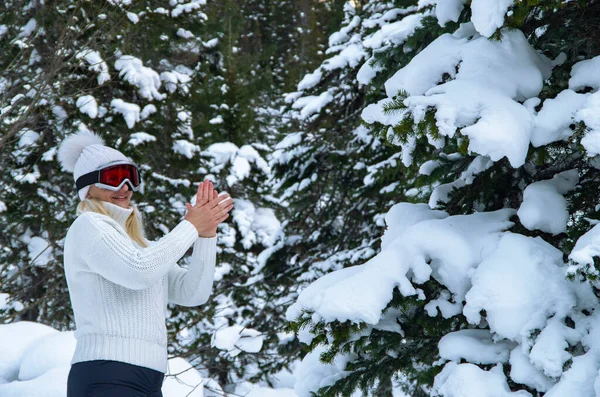 Feliz joven en blanco disfrutando de las vacaciones de invierno en el bosque nevado —  Fotos de Stock