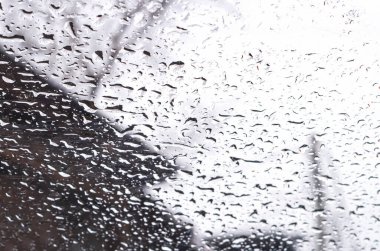 Soyut bulanık arkaplan, arabanın camında kar eriyor