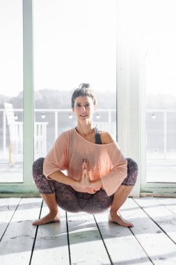 Yoga dersi sırasında çelenk çalan bir kadın.