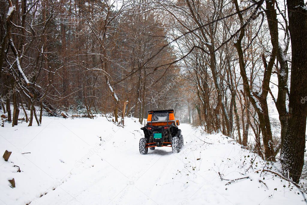 People enjoying their weekend in a off-road buggy on a winter trail