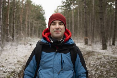 Ormanda yürüyüş kıyafeti giymiş bir adamın portresi.