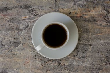 Beton bir masada bir kupa aromatik kahve.