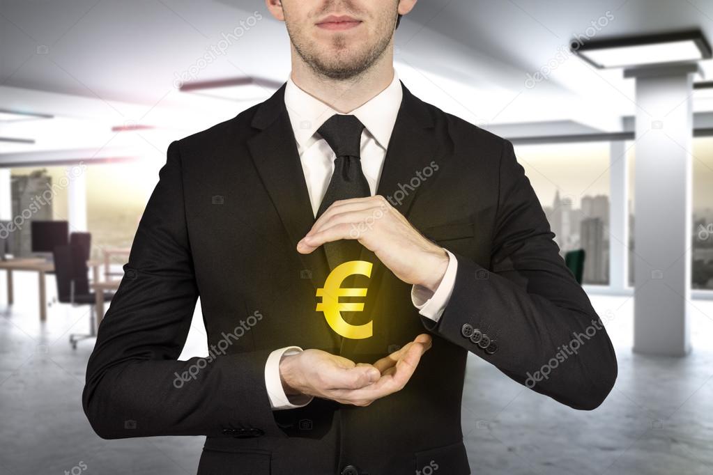 businessman protecting golden eurosymbol