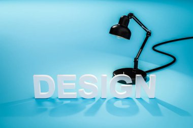 harf dizaynlı mavi yüzey üzerindeki siyah sanayi masa lambası; konsept 3D sanatçı tasarımı; 3D illüstrasyon
