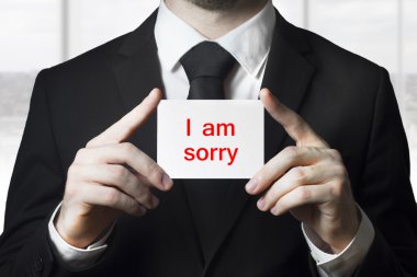 businessman holding sign i am sorry clipart