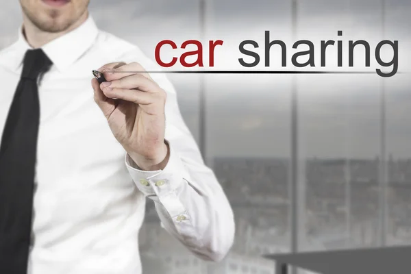 Businessman writing car sharing in the air — Stock Photo, Image