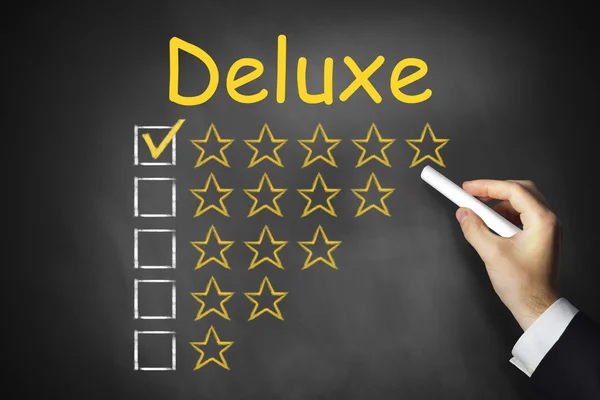 Hand writing deluxe on chalkboard rating stars — Stock Photo, Image