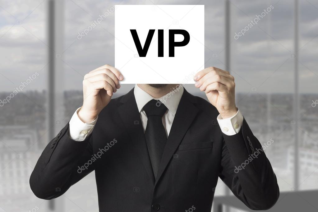 businessman hiding face behind sign vip