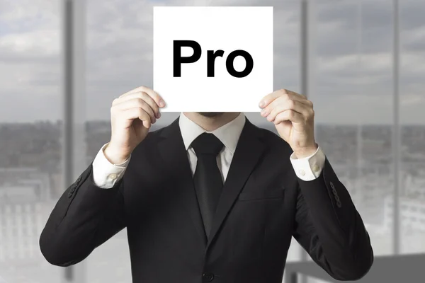 Businessman hiding face behind sign pro — Stock Photo, Image