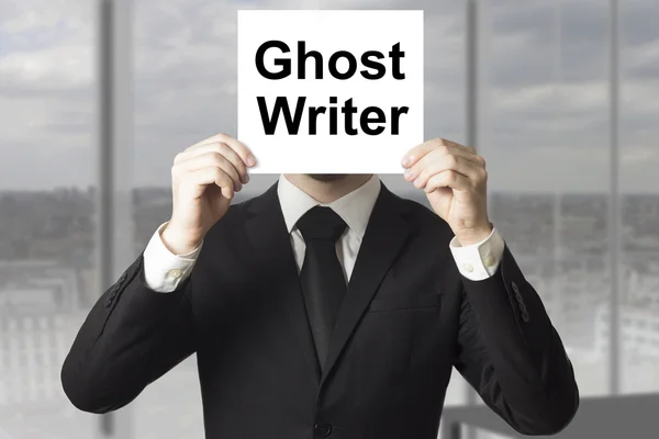 Businessman hiding face behind sign ghost writer — Stock Photo, Image