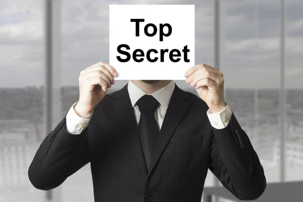 Businessman hiding face behind sign top secret — Stock Photo, Image