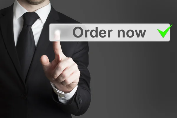 Businessman in black suit pushing button order now — Stock Photo, Image