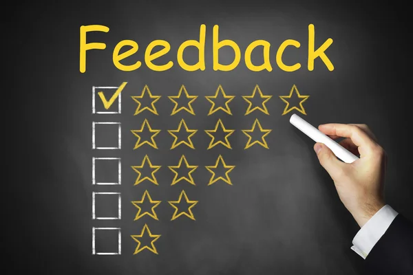 Hand writing feedback on black chalkboard golden rating stars — Stock Photo, Image