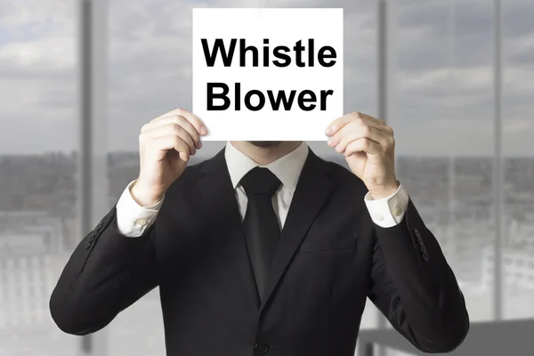 Affärsman som döljer ansiktet bakom tecken whistle blower — Stockfoto