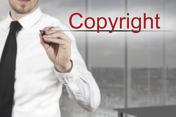 Uomo d'affari che scrive copyright in aria — Foto Stock