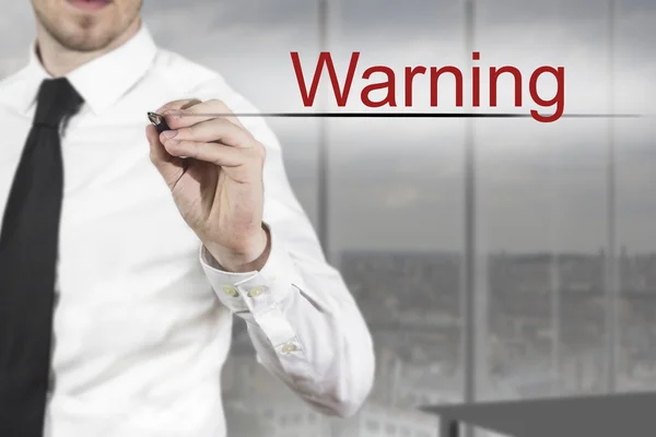 Businessman writing warning in the air — Stock Photo, Image