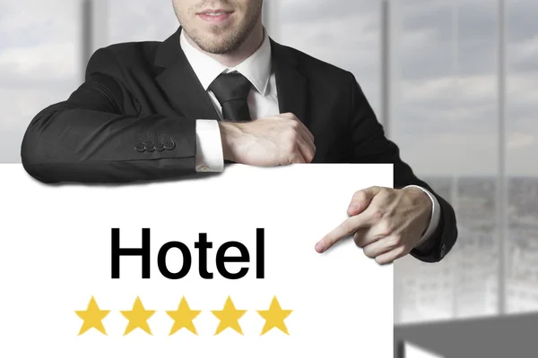 Businessman pointing on sign hotel — Stock Photo, Image